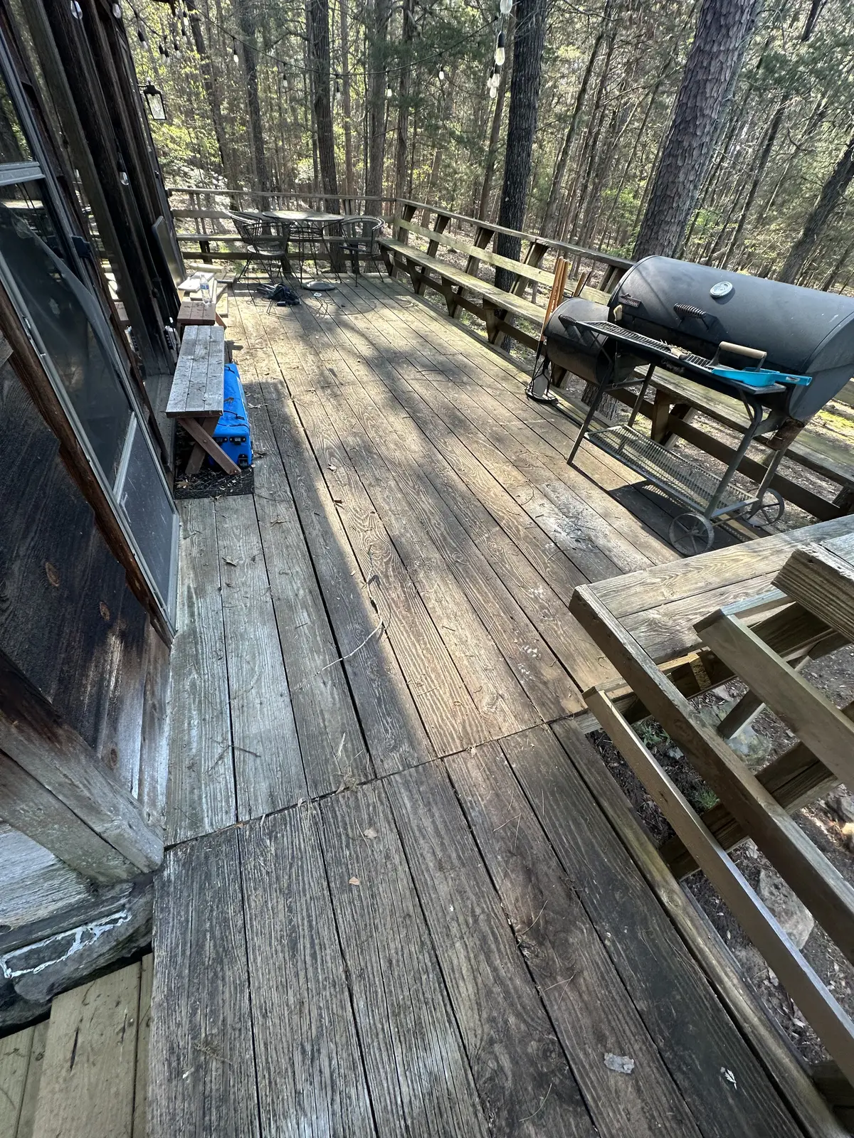 Wood deck before cleaning — grey, weathered boards with organic buildup