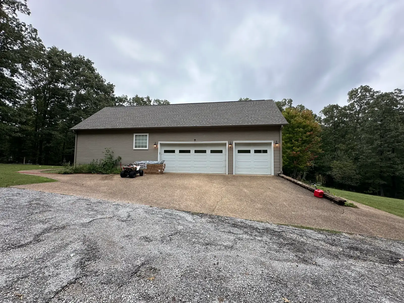 Wide driveway at an Arkansas home before power washing — dull, dirt-stained concrete